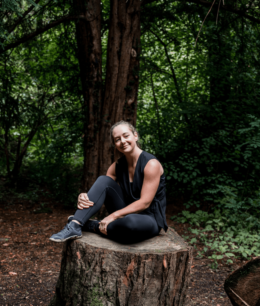 Diane Lillis, personal trainer from Move With Diane, seated on a tree, smiling