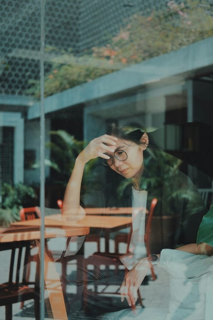 a young anxious mother seated at a table, looking for a solution