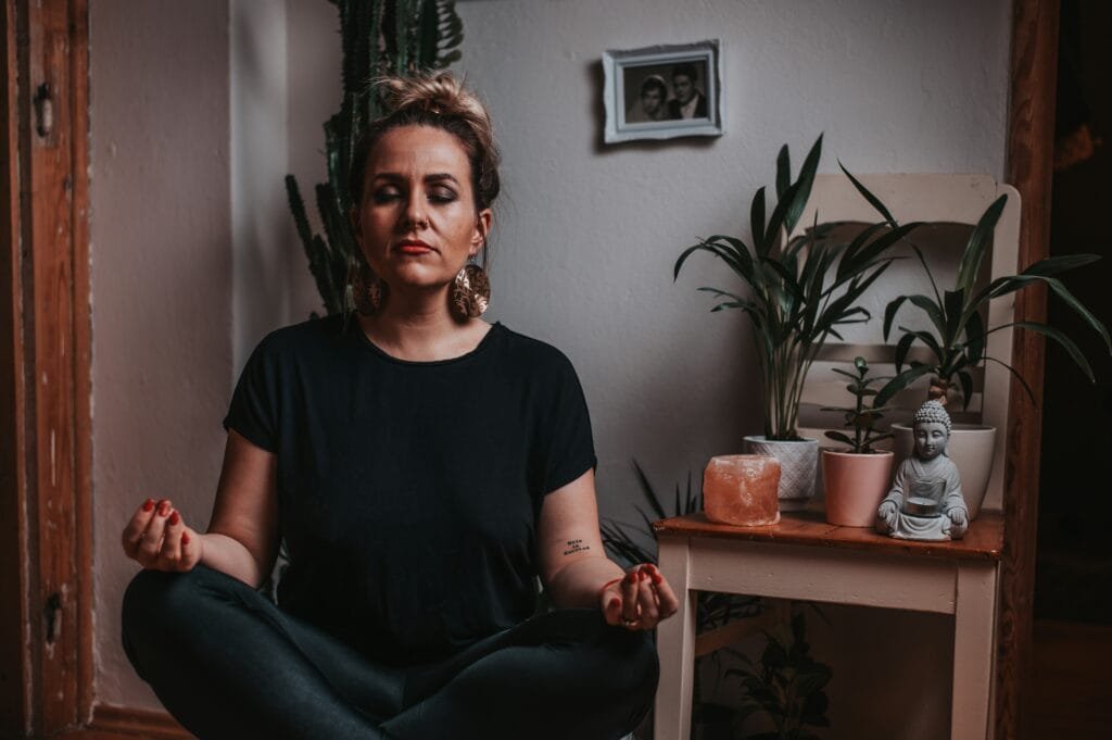 A stressed young mother meditating at home to reduce anxiety