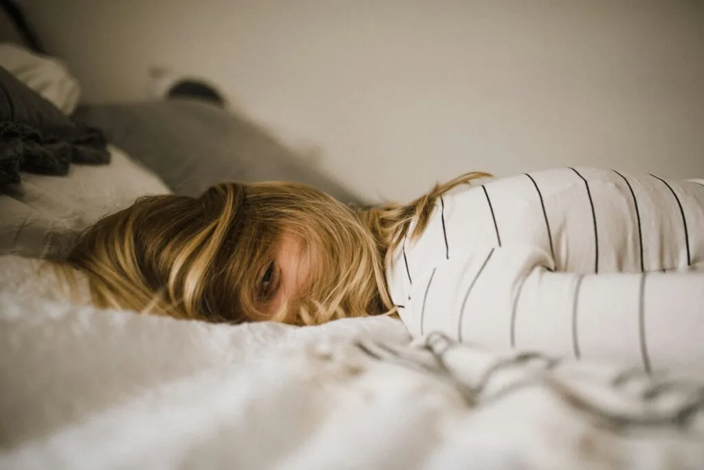 Self care example: a woman spending time in bed to recharge